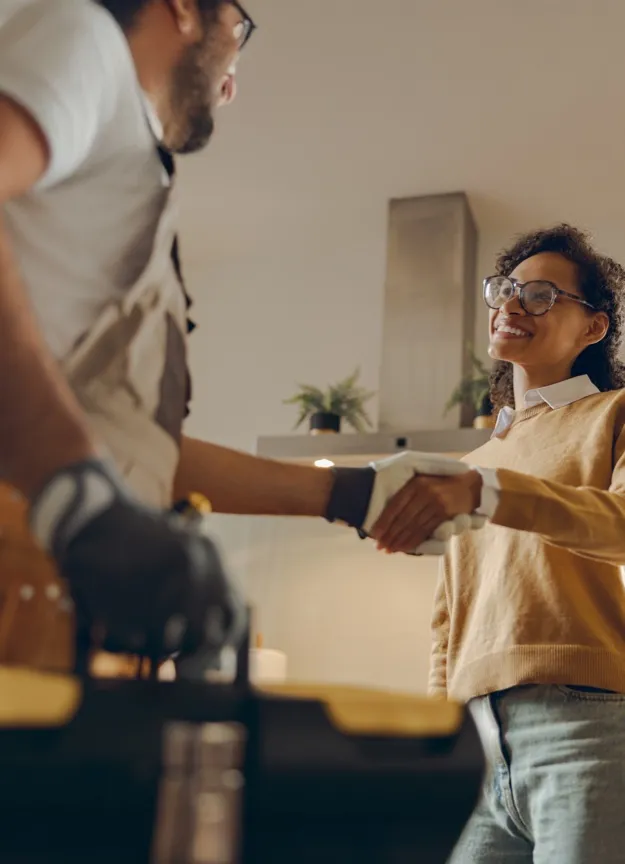 Contractor shaking hands with a homeowner in a kitchen.