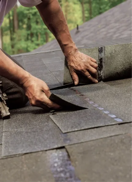 Roofer installing shingles on a residential roof.